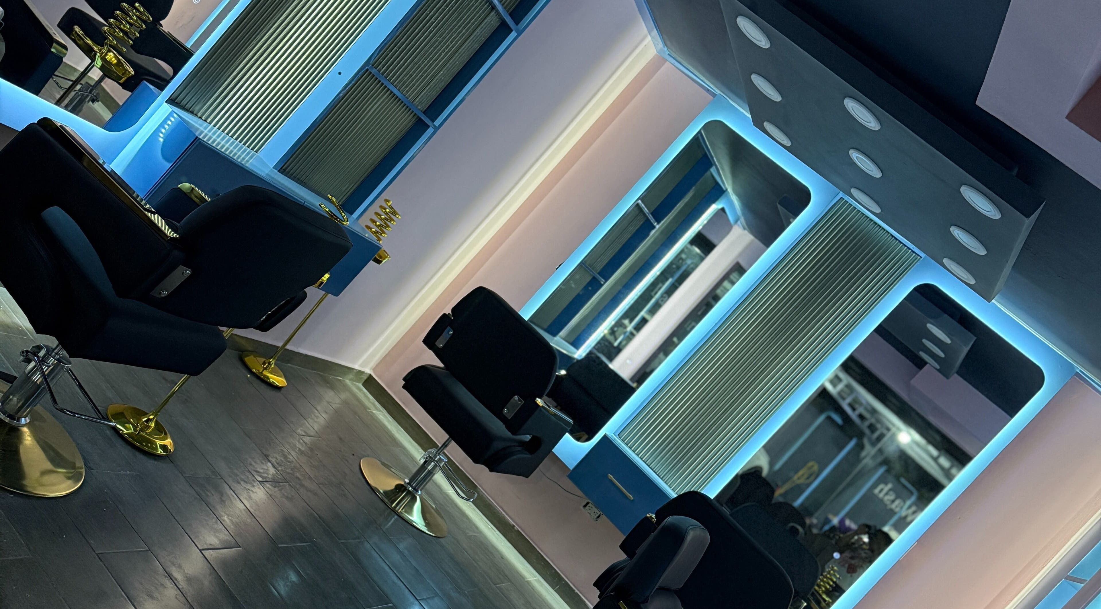 Interior moderno de Blue's Beauty Club en San Francisco De Macorís, Duarte, DO, con sillas y espejos iluminados.