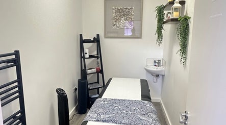 Cozy massage room at RJ Sports Massage Therapy, Cheltenham, England, GB with elegant decor and massage table.