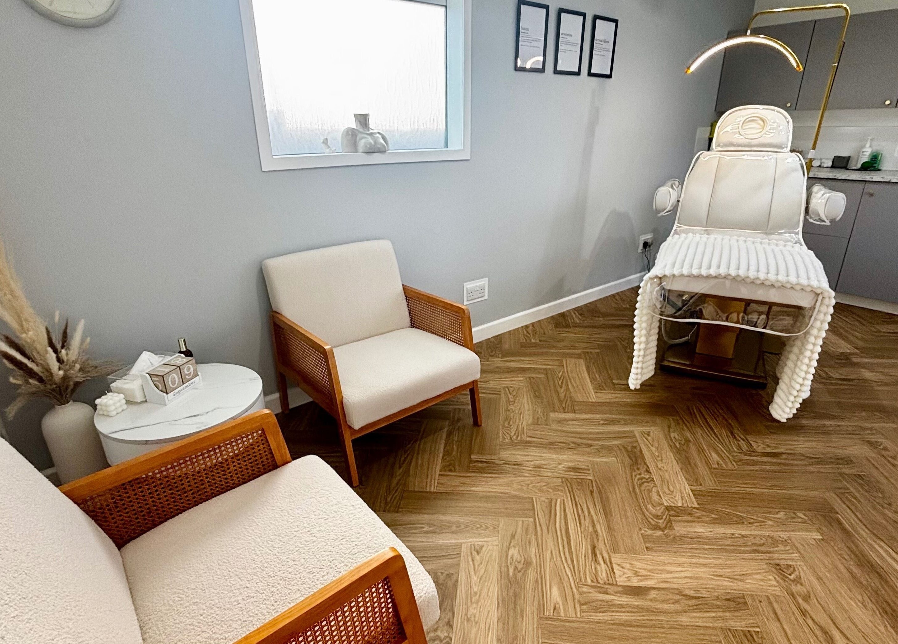 Cozy treatment room at House Of Hamilton Aesthetics, Hemel Hempstead, England, GB with plush seating and a treatment chair.