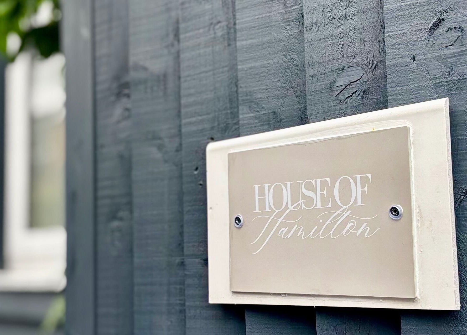 House Of Hamilton Aesthetics sign on grey wood wall, Hemel Hempstead, England, GB.