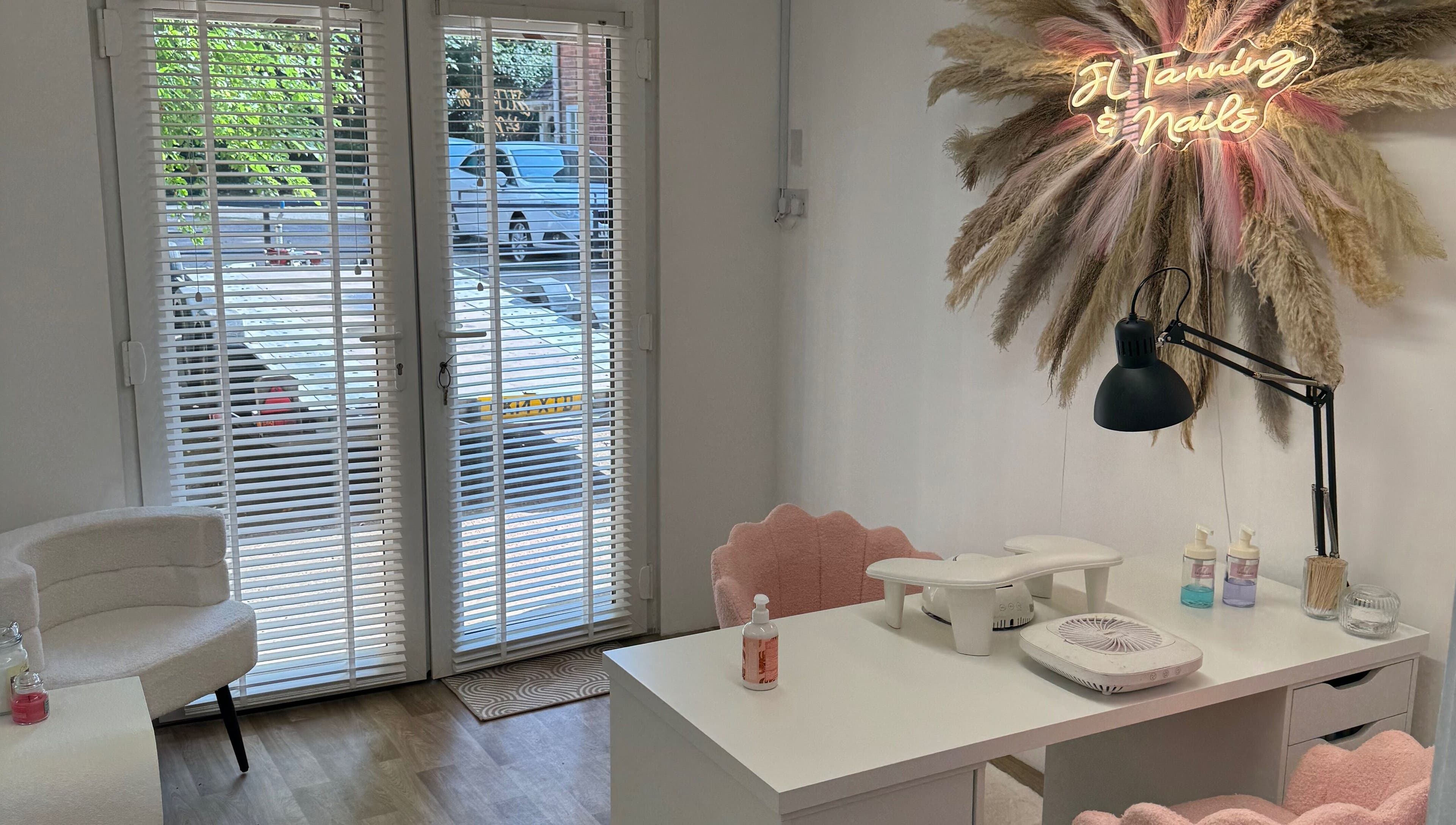 Nail station at JL Tanning and Nails, Exmouth, England, GB with stylish decor and neon sign.