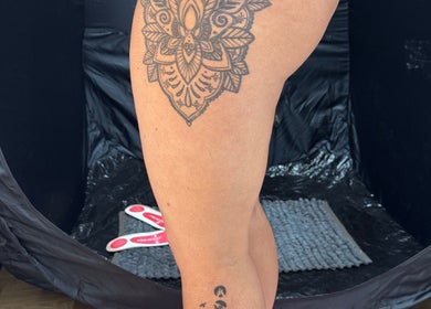 Spray tan setup showcasing tattooed leg at JL Tanning and Nails, Exmouth, England, GB.