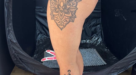 Spray tan setup showcasing tattooed leg at JL Tanning and Nails, Exmouth, England, GB.