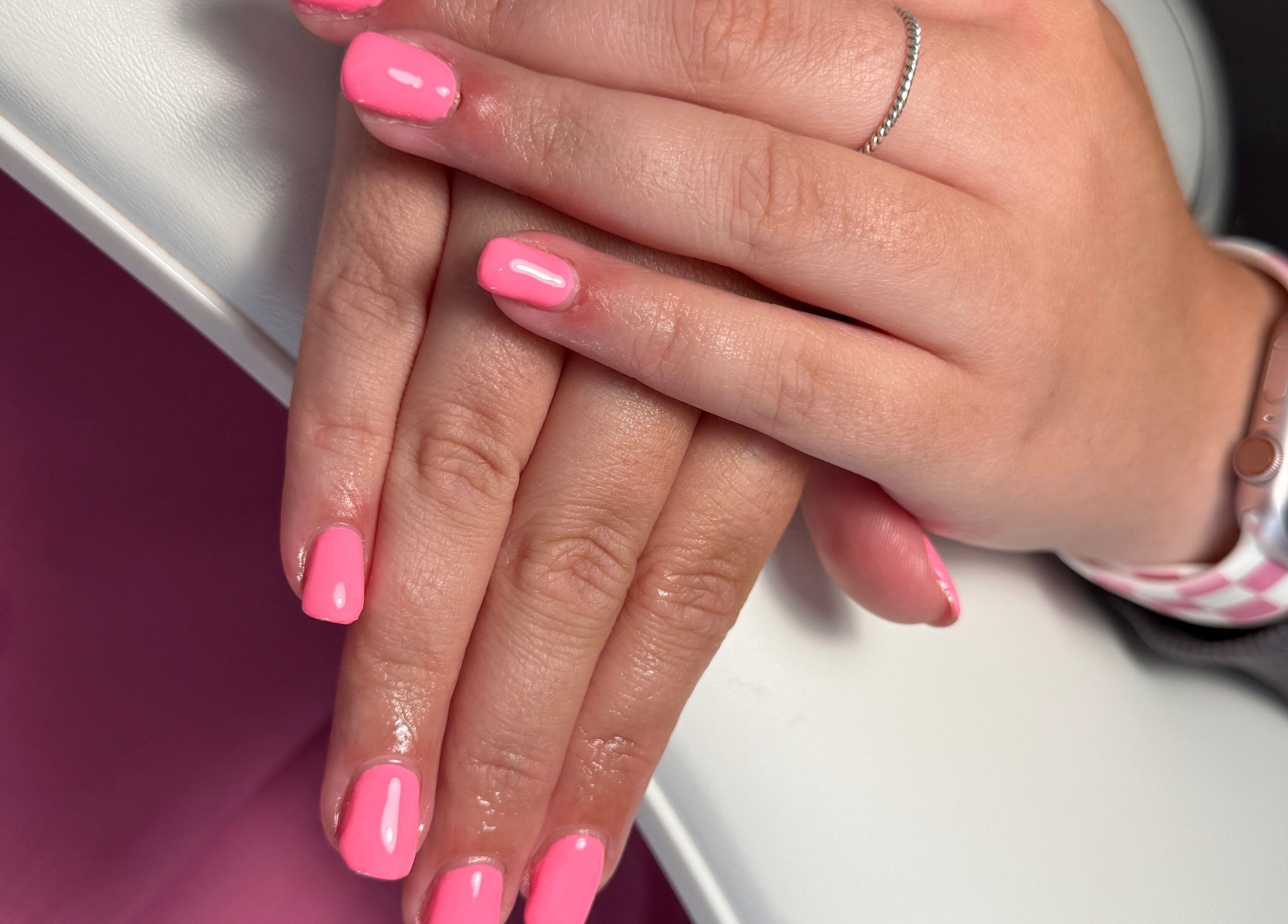 Hand with pink nails at JL Tanning and Nails, Exmouth, England, GB. Perfectly manicured look.
