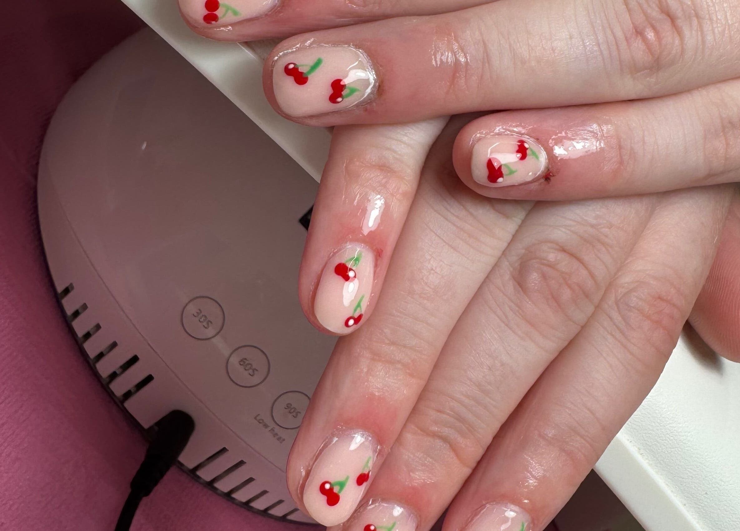 Cherry nail art at JL Tanning and Nails, Exmouth, England, GB. Perfectly manicured hands on display.