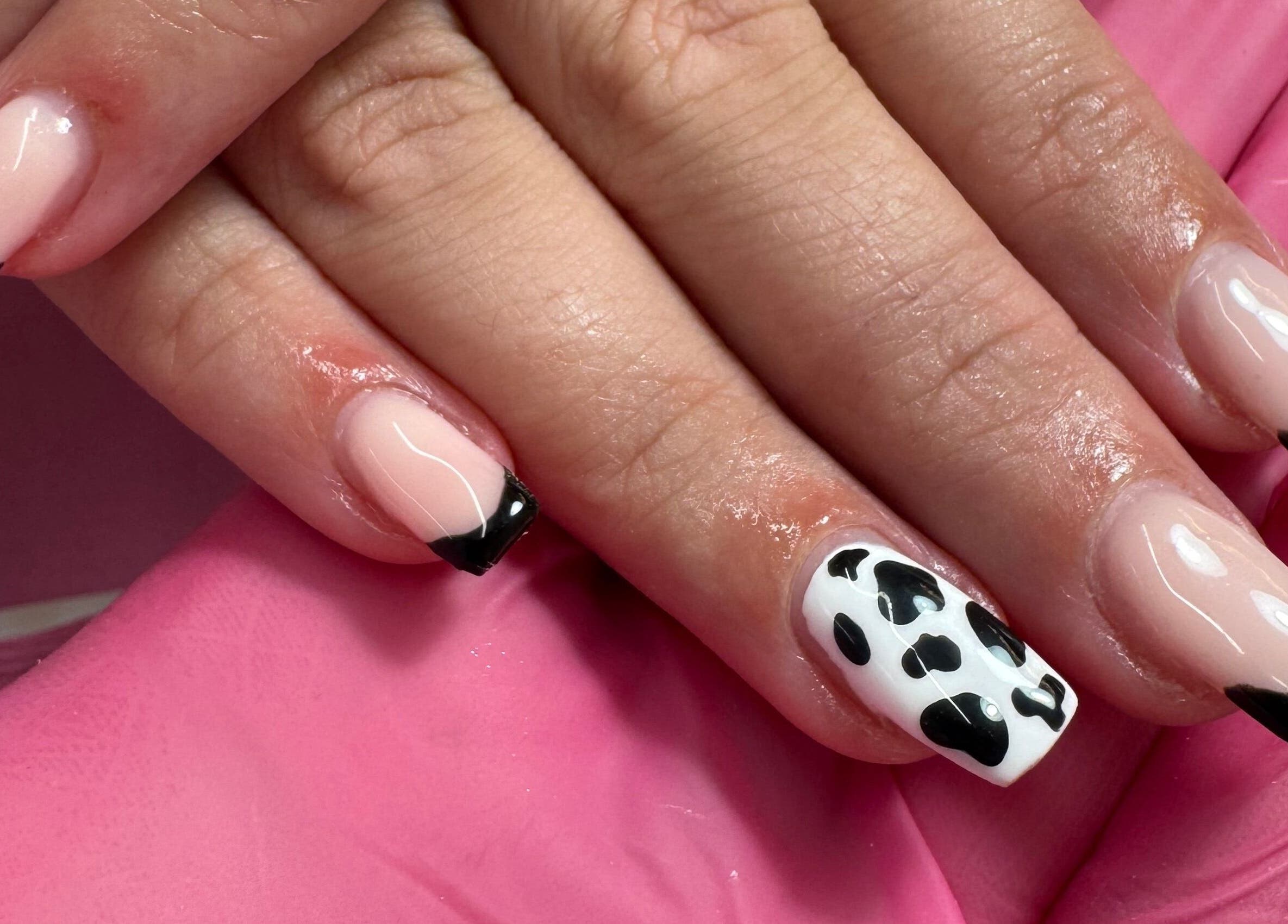 Stylish black French manicure and cow print nail art at JL Tanning and Nails, Exmouth, England, GB.
