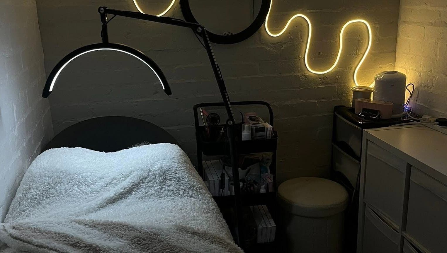 Cozy treatment room at DEFYNED BEAUTY in Wrexham, Cymru, GB with ambient lighting and a comfortable bed.