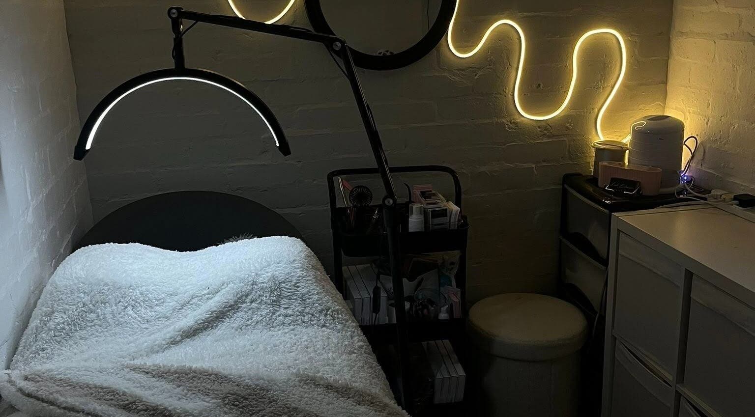 Cozy treatment room at DEFYNED BEAUTY in Wrexham, Cymru, GB with ambient lighting and a comfortable bed.