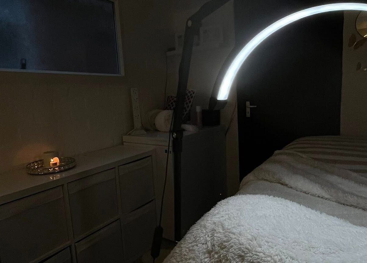 Calming treatment room at DEFYNED BEAUTY, Wrexham, Cymru, GB, featuring a glowing lamp and cozy blanket.