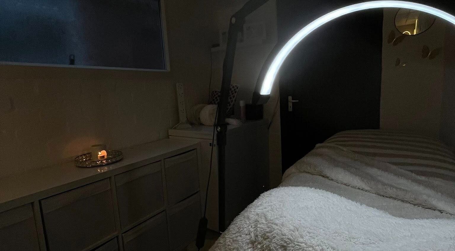 Calming treatment room at DEFYNED BEAUTY, Wrexham, Cymru, GB, featuring a glowing lamp and cozy blanket.