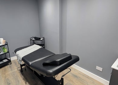 Cozy treatment room at Glowfinity - Woodley, featuring a massage table and essentials. Located in Woodley, England, GB.