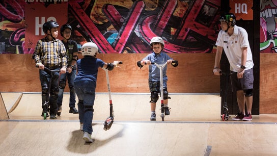 Children riding scooters at Adventure Zone, Dalma Mall, Abu Dhabi, AE. Indoor play area with colorful graffiti.