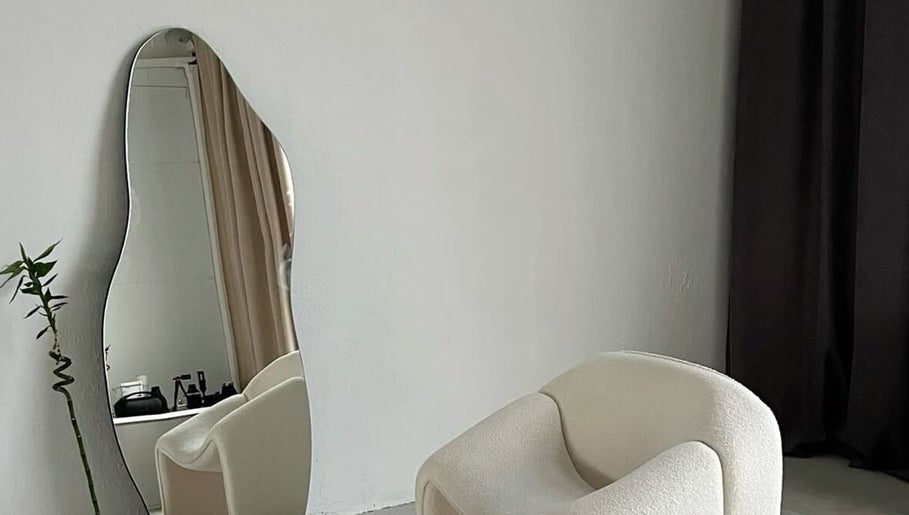 Elegant modern chair by wave mirror at GLAMBY GIA, Melbourne, Victoria, AU. Ideal for serene ambiance.
