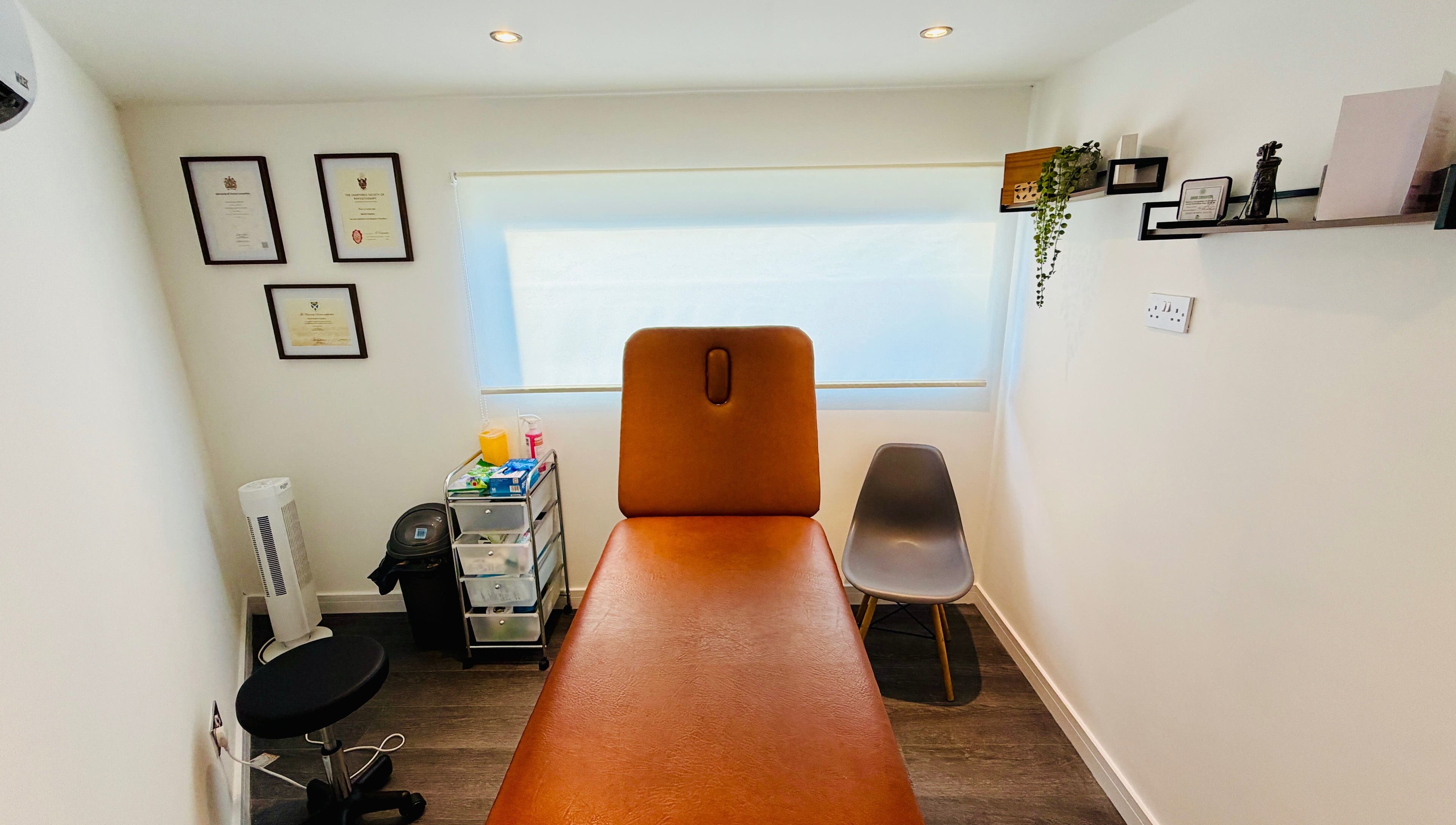 Cozy therapy room at Deaconsbank Physiotherapy, Glasgow, Scotland, GB with treatment bed and certificates.
