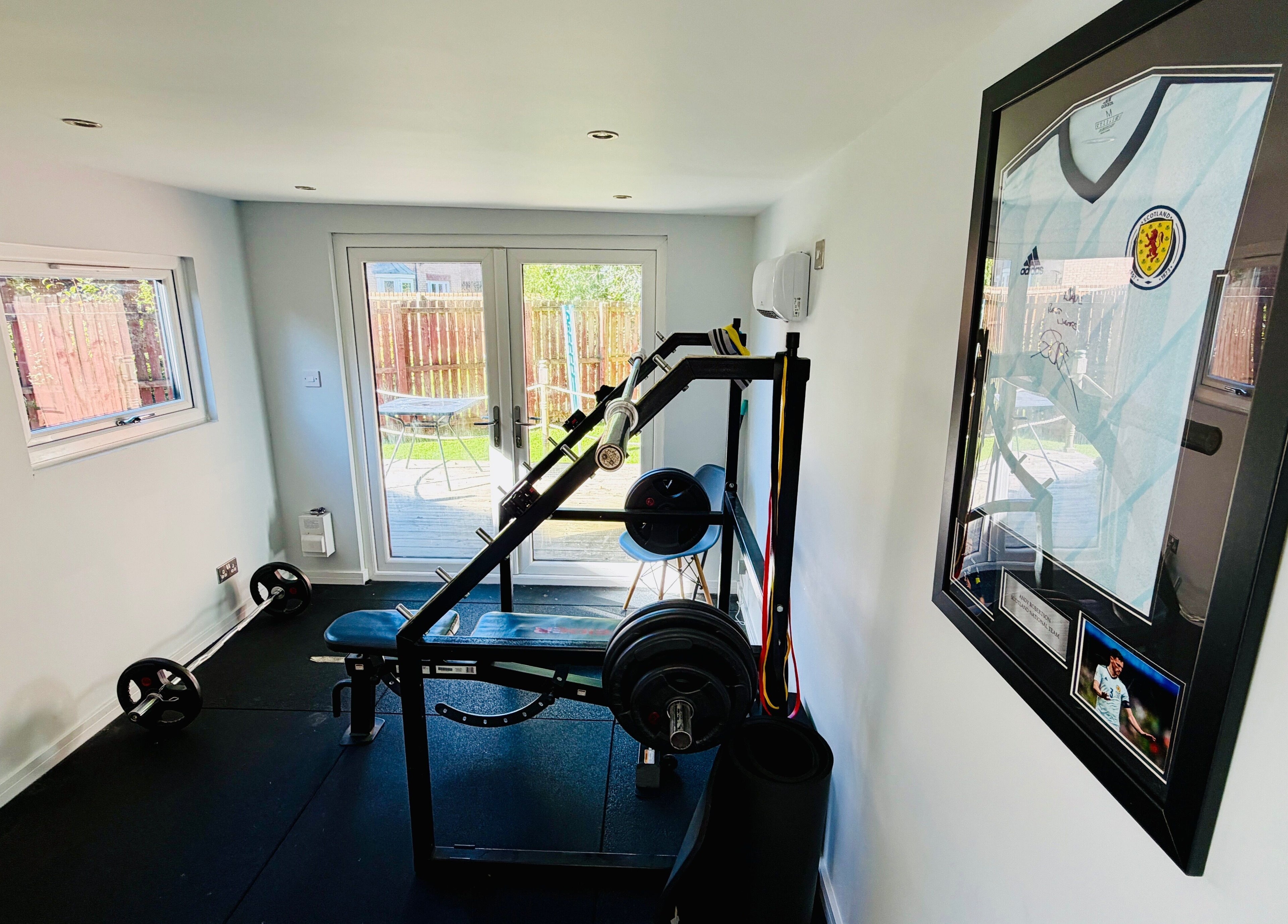 Modern gym at Deaconsbank Physiotherapy, Glasgow, Scotland, GB, featuring weightlifting equipment and bright decor.
