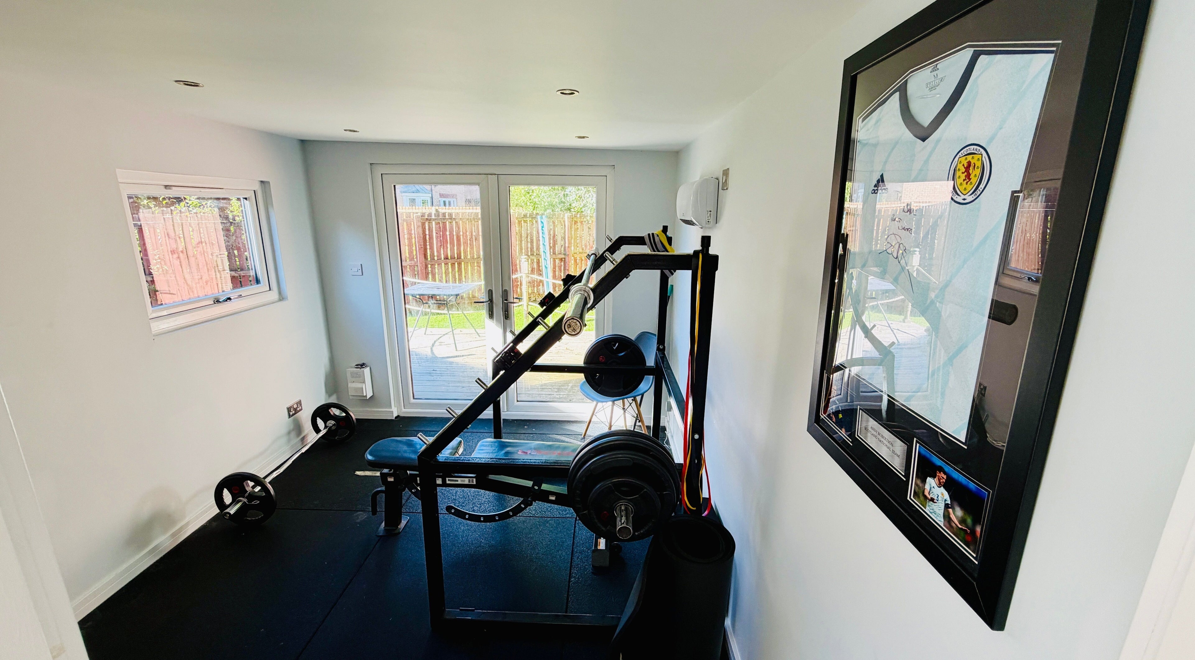 Modern gym at Deaconsbank Physiotherapy, Glasgow, Scotland, GB, featuring weightlifting equipment and bright decor.