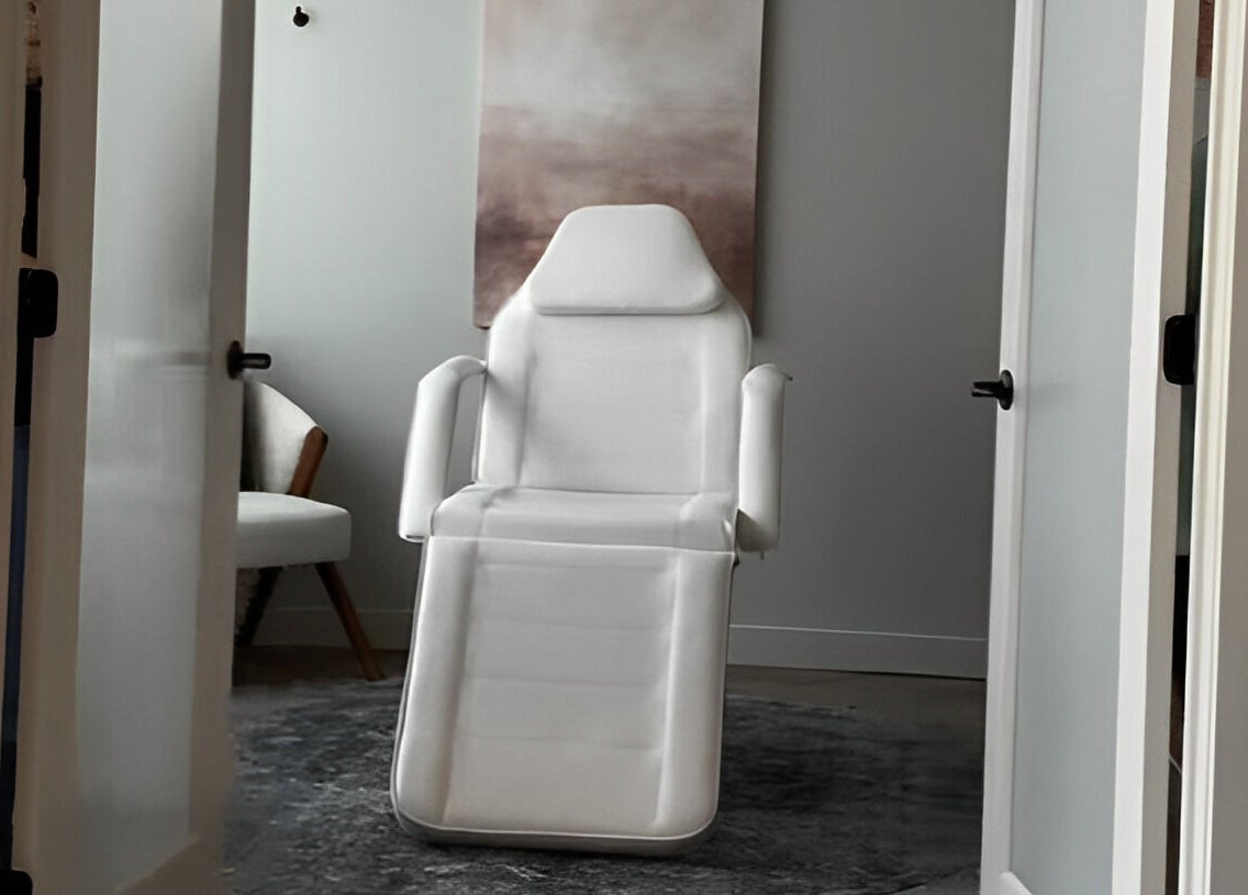 A tranquil treatment room at La Luma Spa & Aesthetics in Drumheller, Alberta, CA with a white chair.