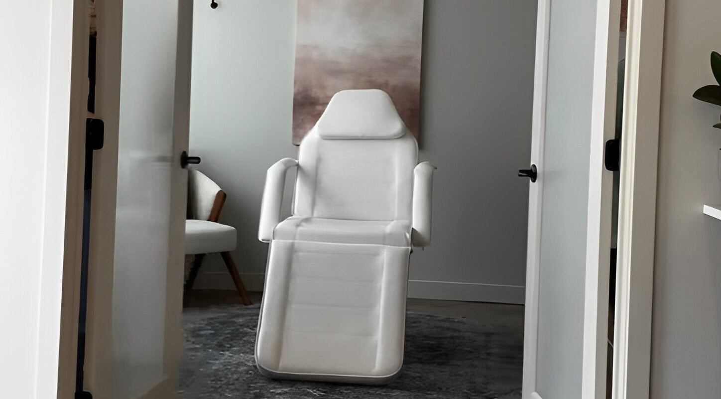 A tranquil treatment room at La Luma Spa & Aesthetics in Drumheller, Alberta, CA with a white chair.