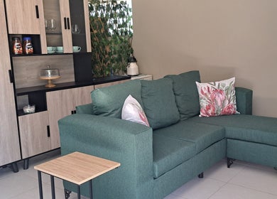 Elegant green sofa in cozy lounge at Scissors And Style, Pretoria, Gauteng, ZA.