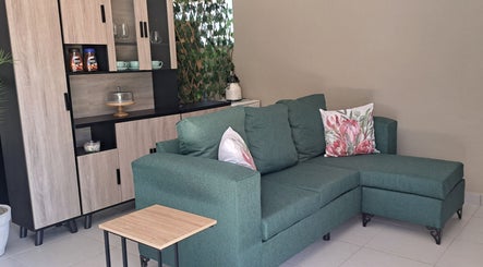 Elegant green sofa in cozy lounge at Scissors And Style, Pretoria, Gauteng, ZA.