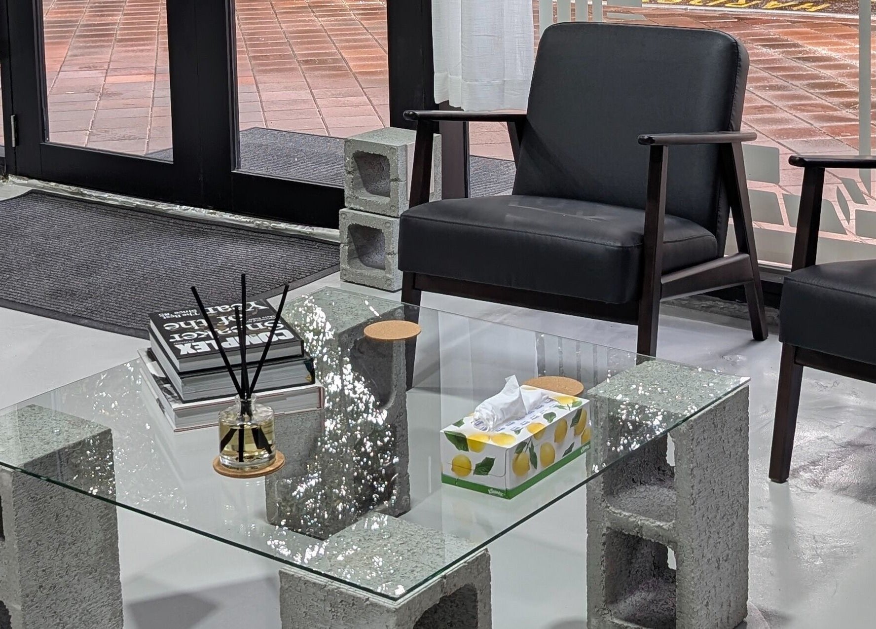 Modern seating at Sanctum Studio Perth in Subiaco, Western Australia, AU with glass table and black chairs.