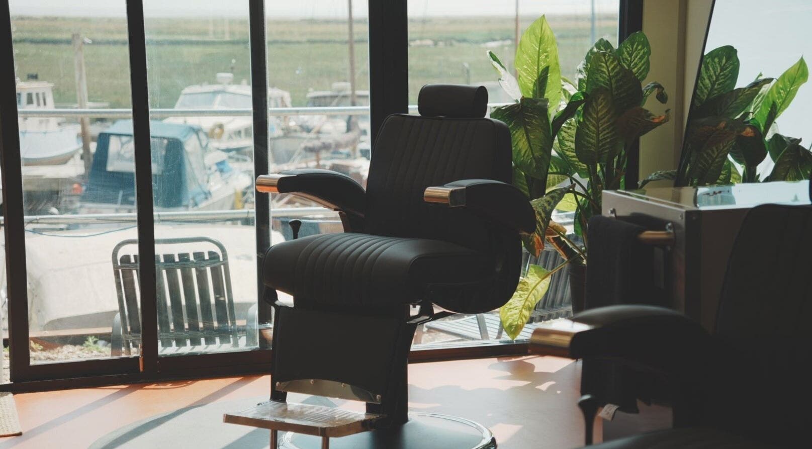 Comfortable barber chair at Wave Barber Studio, Southend-on-sea, England, GB, overlooking marina views.