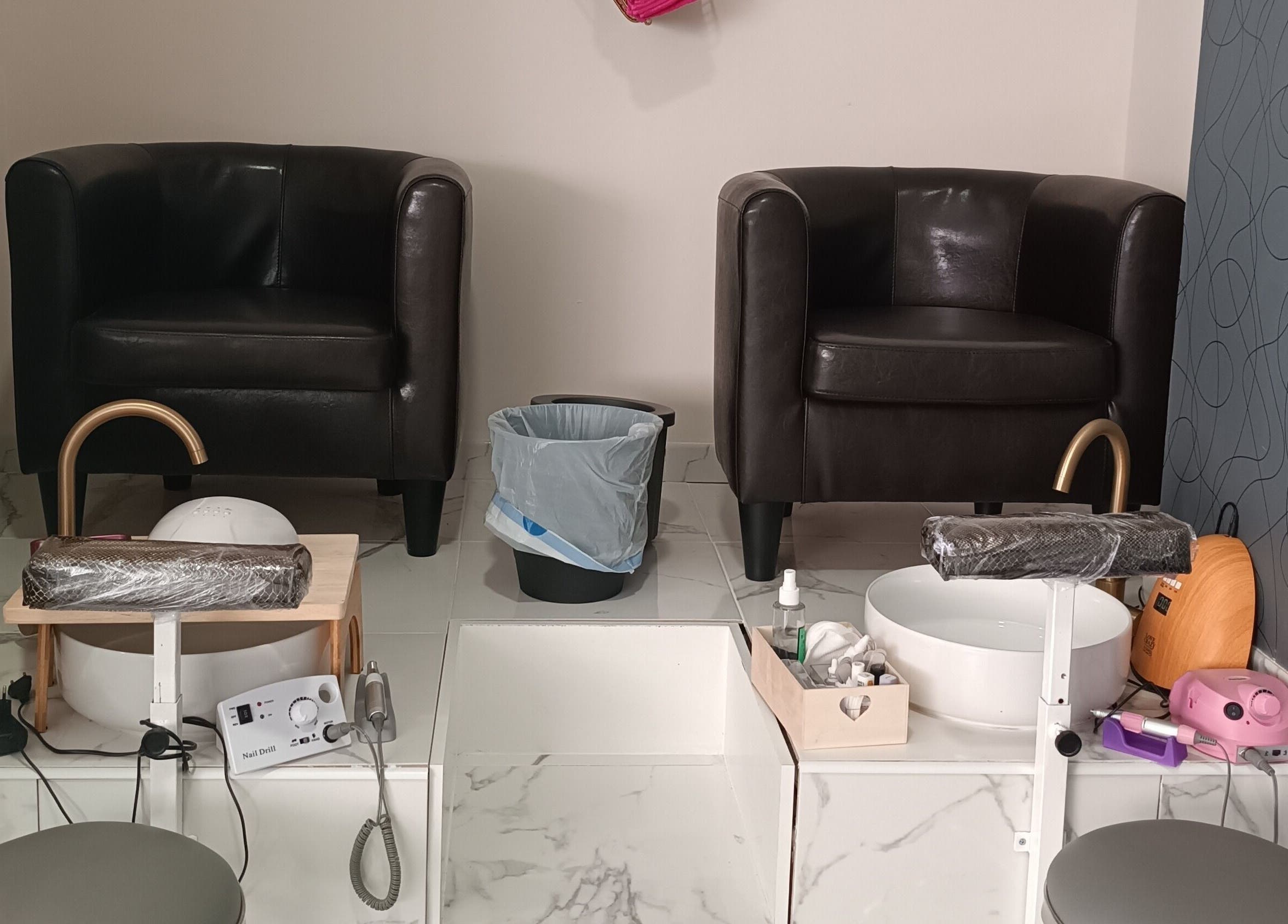 Zona de pedicura en Glowy Beauty Salon, Sagunt, Comunidad Valenciana, ES, con sillones marrones cómodos.