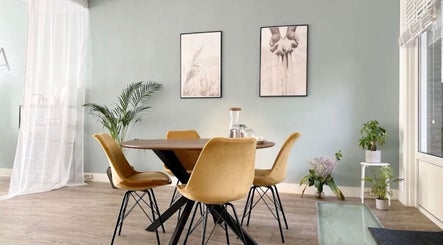 Stijlvolle zithoek bij Cozynailroom in Amsterdam, Noord-Holland, NL, met gele stoelen en planten.