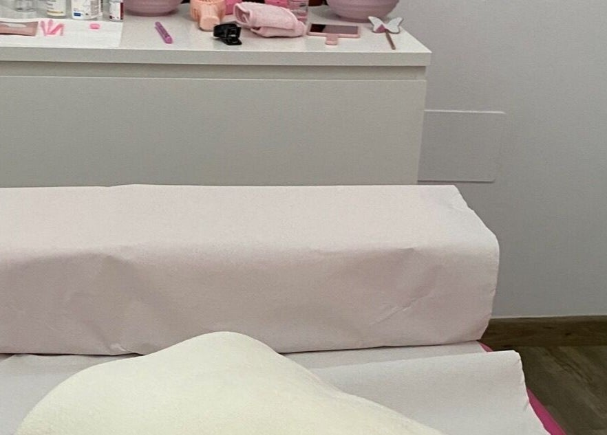 Sala de tratamiento en Áurea Centro de Estética 🌿 en Teixeiro, ES, con camilla acolchada para relajación.