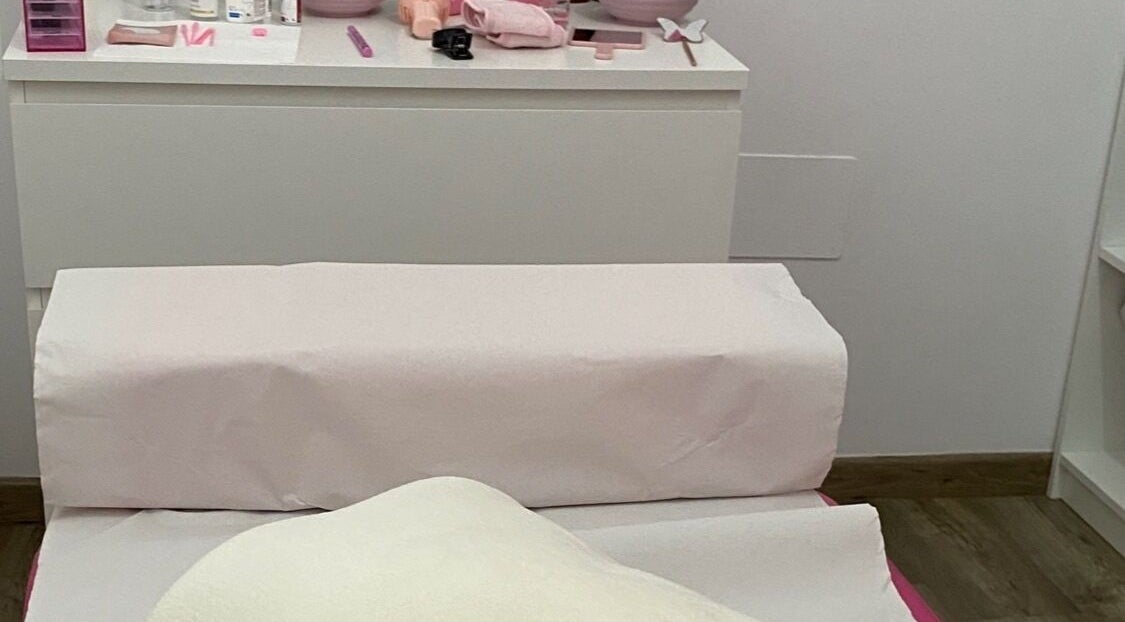 Sala de tratamiento en Áurea Centro de Estética 🌿 en Teixeiro, ES, con camilla acolchada para relajación.