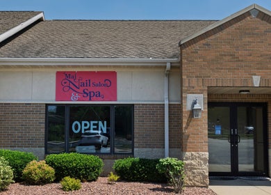 Front entrance of Mai Nail Salon & Spa in Appleton, Wisconsin, US, featuring open sign and greenery.