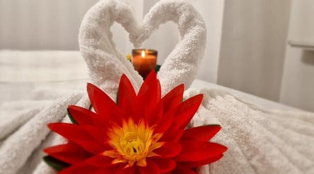 Elegant towel swans with a vibrant red flower at KHUN MAI THAI MASSAGE, London, England, GB.