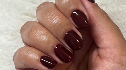 Close-up of maroon nails at IC Nails, Aylesbury, England, GB showcasing sleek manicure finish.