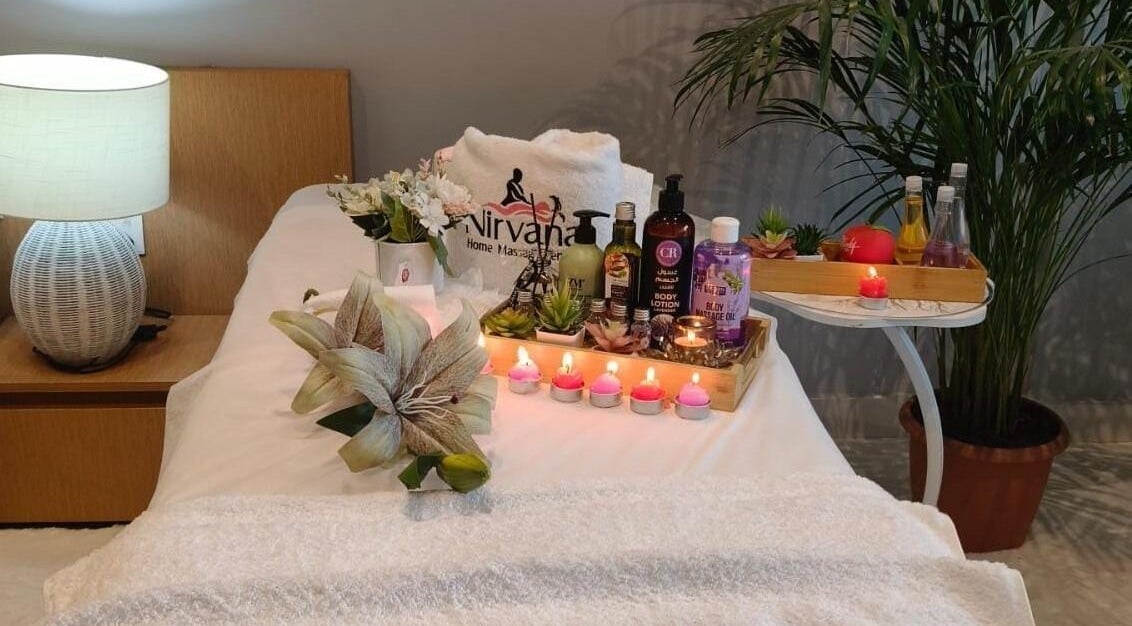 Tranquil spa setup at Nirvana Home Spa Service, Dubai, Dubai, AE with candles, oils, and fresh flowers.