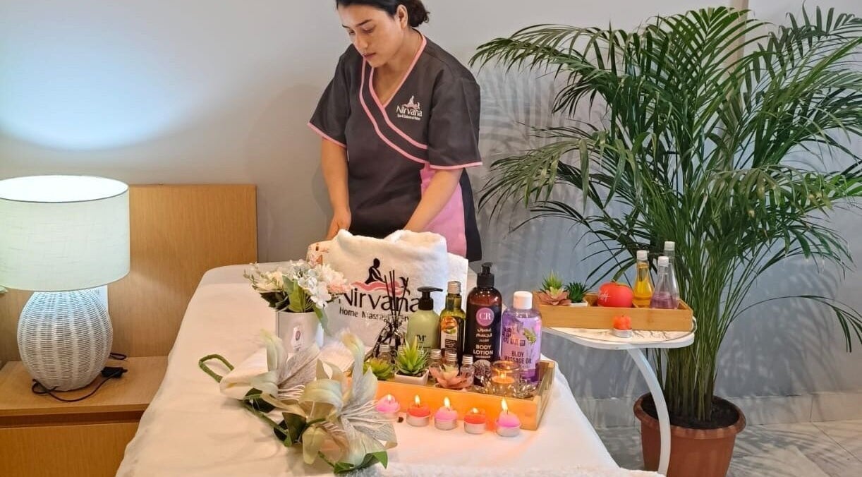 Massage therapist preparing relaxation area at Nirvana Home Spa Service, Dubai, Dubai, AE.