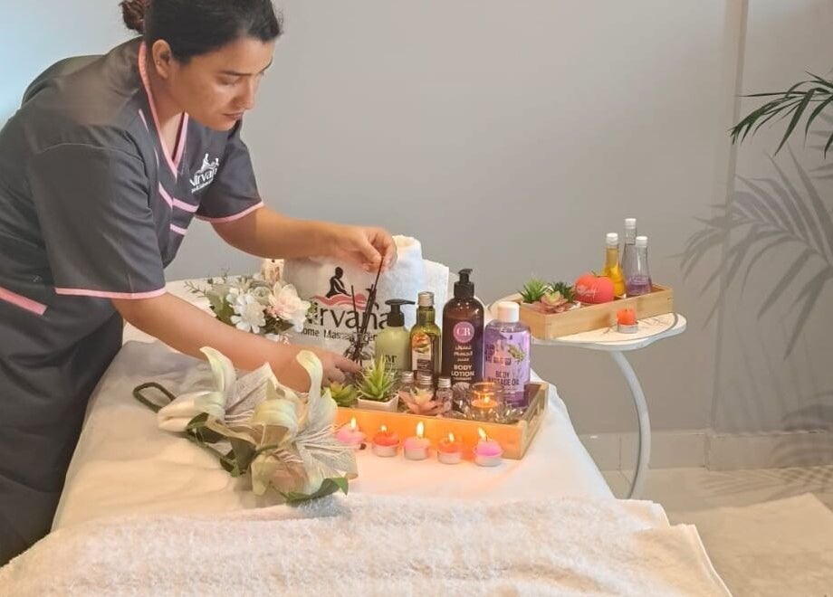 Therapist arranging spa items at Nirvana Home Spa Service, Dubai, Dubai, AE, creating a tranquil atmosphere.