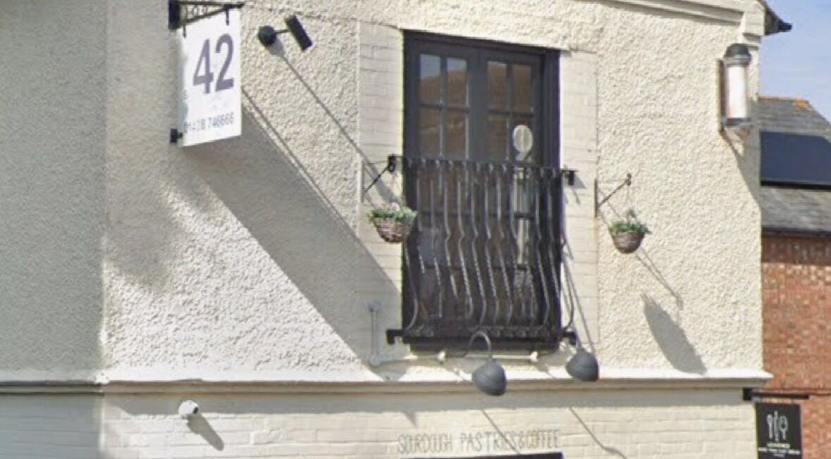 Front view of Beauty, Hair & Beyond's rustic exterior in Stevenage, England, GB, with hanging plants.