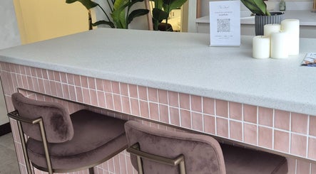 Stylish pink tiled counter with plush chairs at Medermica, Bristol, England, GB offers a welcoming ambiance.