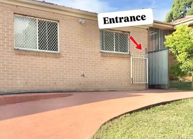 Entrance to Her Lash Escape in Minto, New South Wales, AU, featuring brickwork and lush greenery.