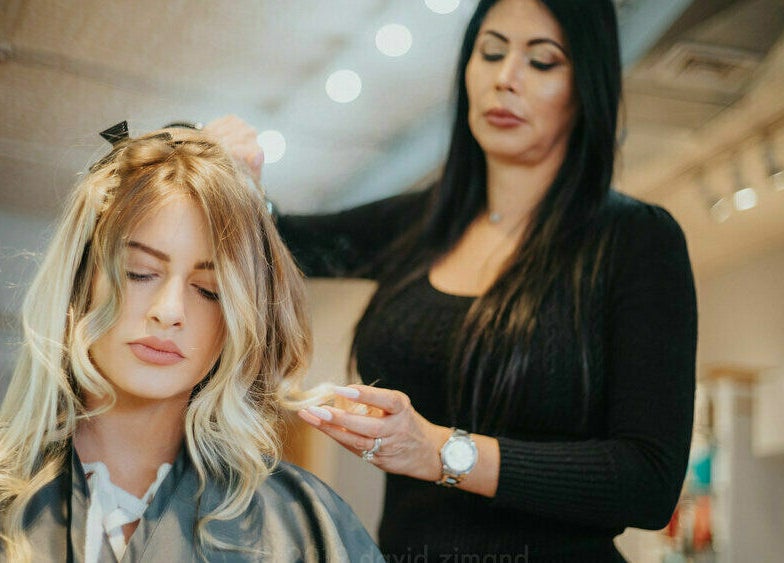 Stylist crafting elegant blonde curls at DaVinci Hair Studio, Englewood, New Jersey, US.