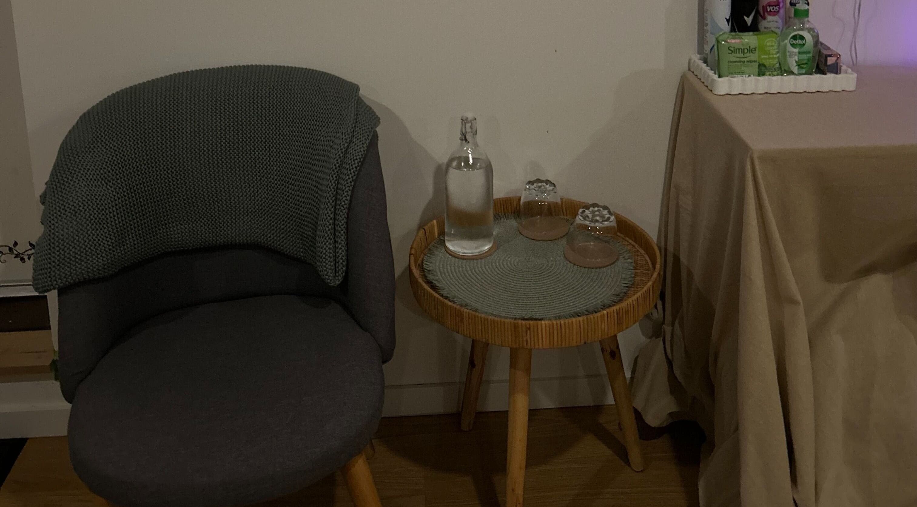 Cozy seating area at Skin Deep Massage Therapy, Crib Point, Victoria, AU with a chair, table, and essentials.