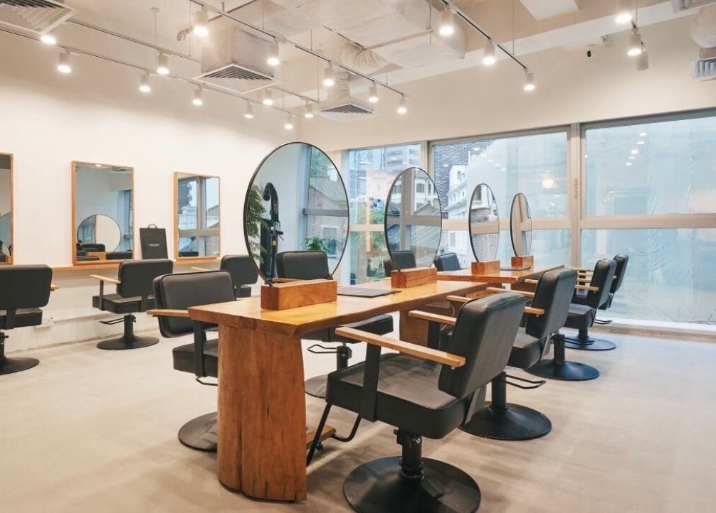 Salon Nozomi現代設計的內景，位於香港島, 香港島, HK，展示時尚髮型椅和大窗戶。