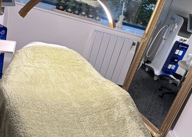 Treatment room at Shades of Beauty, Aylesbury, England, GB with cozy bed and beauty equipment.