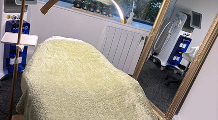 Treatment room at Shades of Beauty, Aylesbury, England, GB with cozy bed and beauty equipment.
