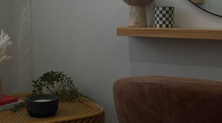 Cozy decor at A Designs, Killarney Vale, New South Wales, AU featuring a shelf, vase, and cushioned chair.