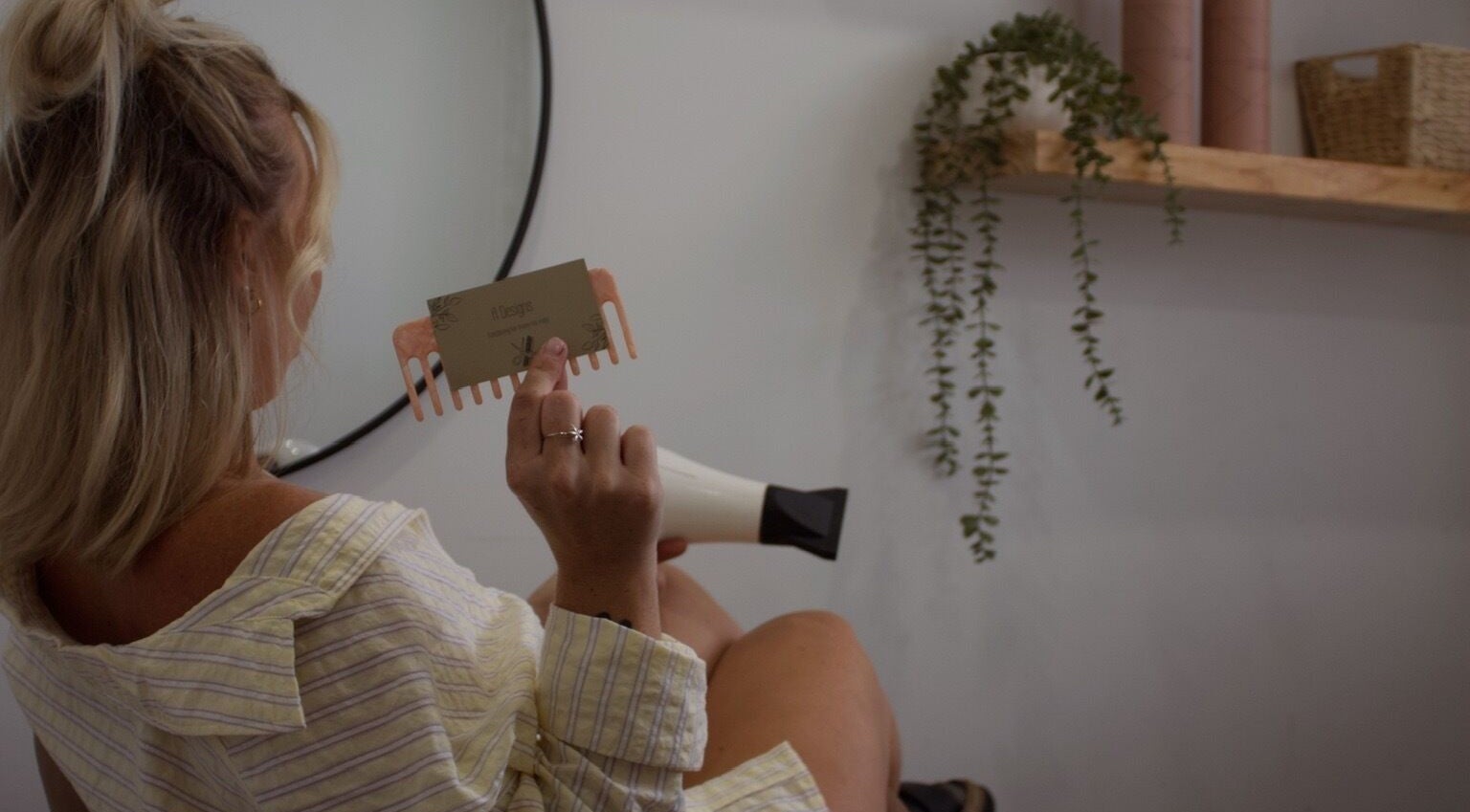 Woman holds A Designs comb at Killarney Vale, New South Wales, AU beauty salon.