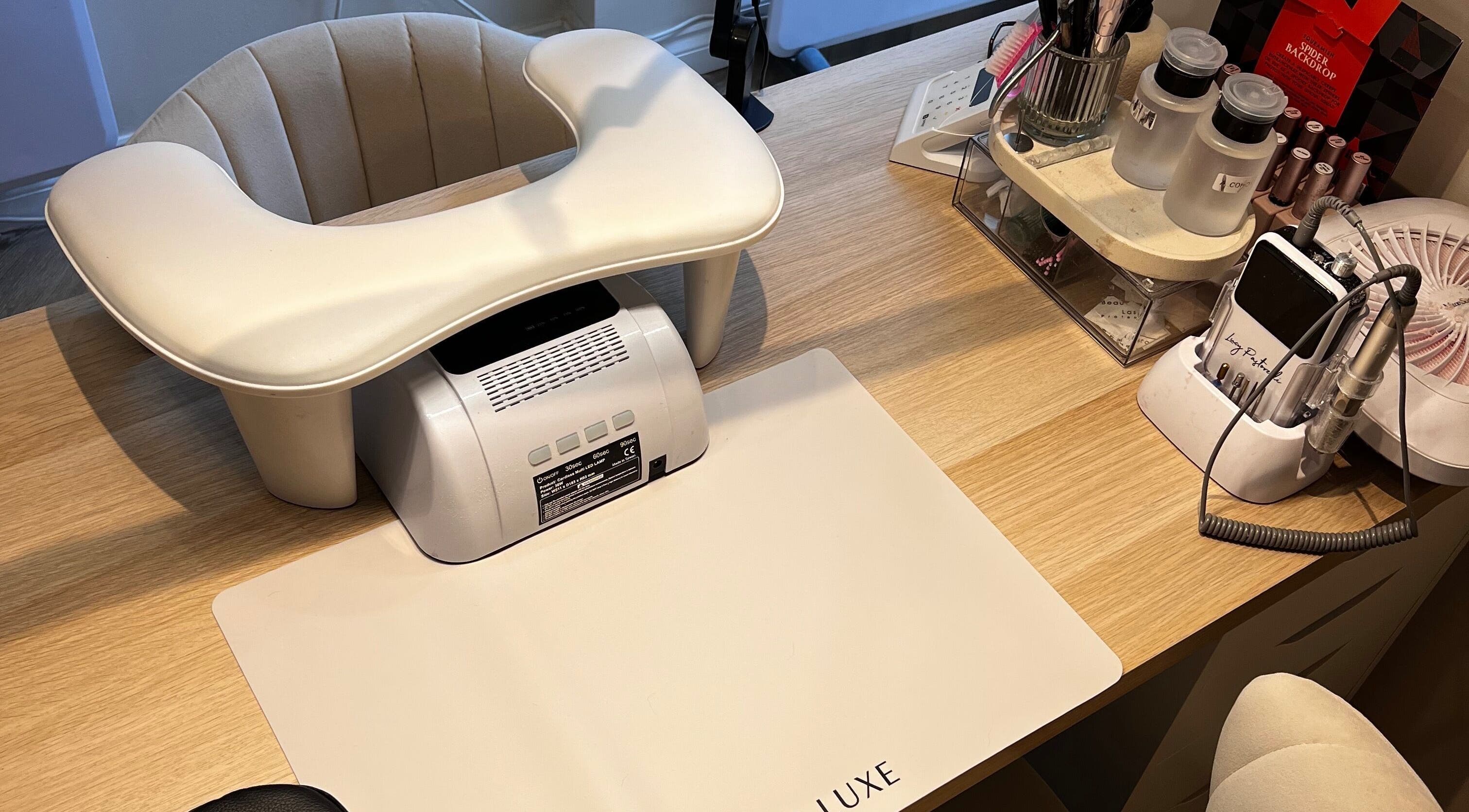 Modern nail tech station at At Your Finger Tips in Cambuslang, Scotland, GB, with manicure tools and equipment.