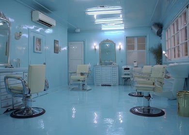 Elegant blue salon interior at Heaven Luxe Aesthetics in London, England, GB with chic mirrors and stylish chairs.