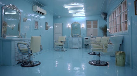 Elegant blue salon interior at Heaven Luxe Aesthetics in London, England, GB with chic mirrors and stylish chairs.