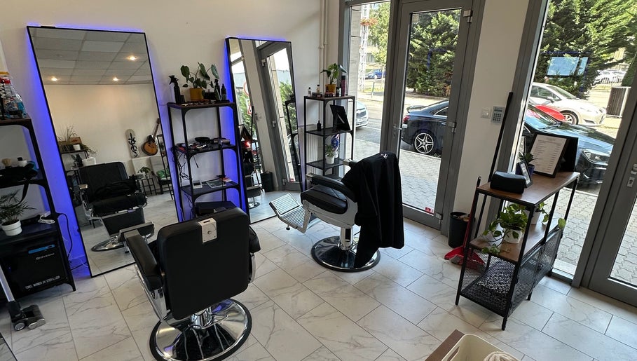 Modern interior of Újlipót Barber Shop in Budapest, Magyar, HU with sleek chairs and well-lit mirrors.